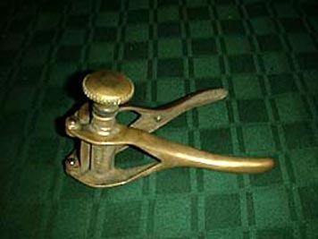 large photo of small hand-held brass bottle corker